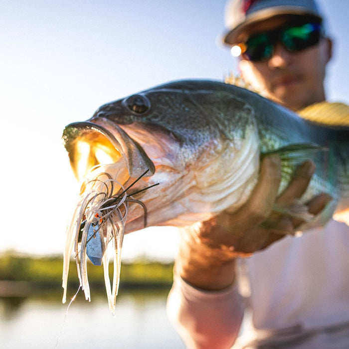 Image of a sport fisherman holding a bass with a ChatterBait in its mouth